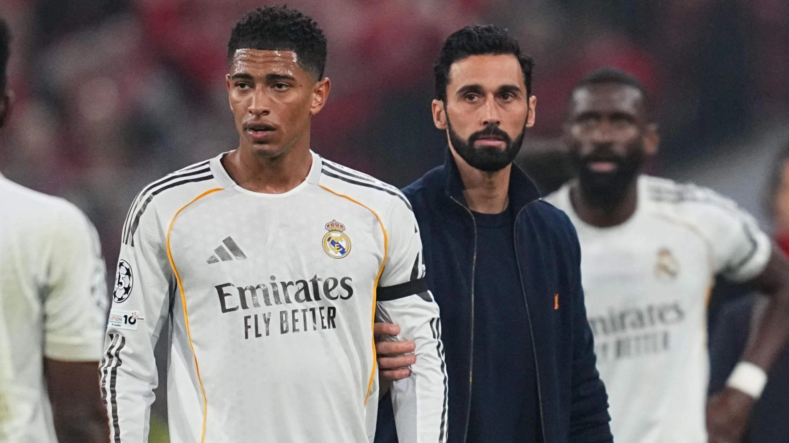 Real Madrid's Jude Bellingham is held back by manager Alvaro Arbeloa after they are knocked out of the Champions League by Bayern Munich