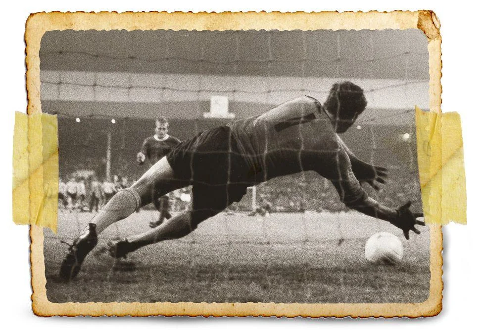 Black and white photo shows goalkeeper Ian McKechnie diving to his right